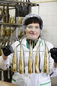 Fish factory.Fish factory worker holds smoked fish.