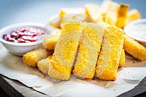 Fish finger and french fries or chips with tomato ketchup and mayonnaise sauce