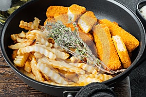 Fish fingers and Chips british fast food with tartar sauce, on frying iron pan