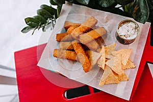 Fish fingers with crispy nachos along with tartar sauce