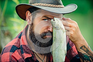 Fish and fishing concept. Fly angler man on the river. Portrait of cheerful man fishing. Angler portrait close up.
