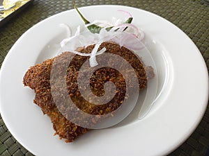 Fish fry served hot on a white plate.