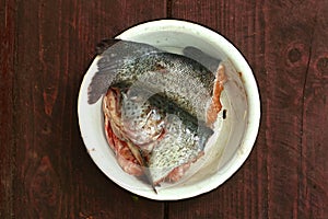 Fish head and tale close up photo in bowl ready for soup cooking