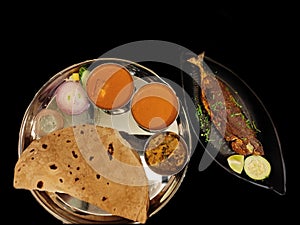 Fish meal served with chapati, fish curry, vegetable, fried fish and salad in a steel plate