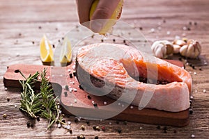 Fish Menu. Cook man plating salmon steak squeezing lemon juice. Selective Focus