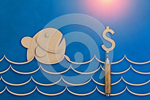 Fish and money symbol paper cut on blue leather background