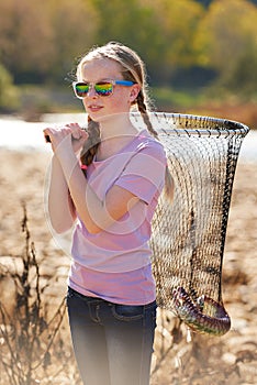 Fish net, nature and girl child with sunglasses for outdoor activity on weekend camp trip. Fishing, pond and young kid