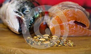 Fish oil capsules on the background of a salmon head and a piece of red fish,