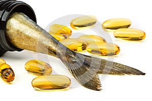 Fish oil capsules and fish tail in brown jar