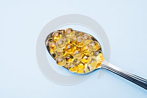 Fish oil capsules with omega 3 and vitamin D blue texture, healthy diet concept, selective focus