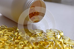 Fish oil capsules with omega 3 and vitamin D in a bottle on wooden texture, healthy diet concept,close up shot
