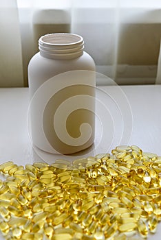 Fish oil capsules with omega 3 and vitamin D in a bottle on wooden texture, healthy diet concept,close up shot