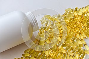 Fish oil capsules with omega 3 and vitamin D in a bottle on wooden texture, healthy diet concept,close up shot. Top view