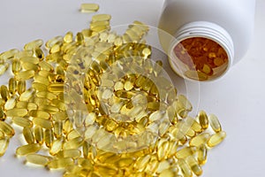 Fish oil capsules with omega 3 and vitamin D in a bottle on wooden texture, healthy diet concept,close up shot. Top view