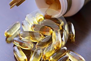 Fish oil capsules with omega 3 and vitamin D in a glass bottle