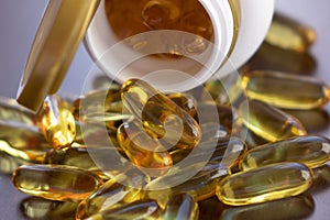 Fish oil capsules with omega 3 and vitamin D in a glass bottle