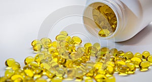 Fish oil capsules with omega 3 and vitamin D, isolated on white background. Yellow vitamin pills. Medicine and healthy