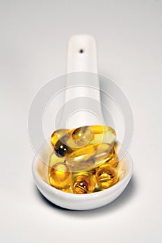 Fish oil capsules on spoon