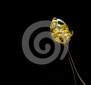 Fish Oil Capsules in spoon on black background - pharmaceutical concept. Selective focus