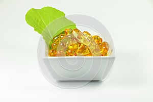 Fish oil capsules with vegetable leaf in cup