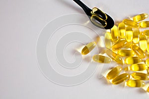 Fish oil capsules on white background with free space for text. In a spoonful of fish oil capsules