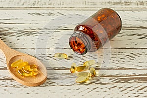 Fish oil capsules on wooden background and texture  vitamin D  omega supplement  selective focus