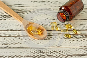 Fish oil capsules on wooden background and texture  vitamin D  omega supplement  selective focus