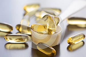 Fish oil capsules on wooden background and texture, vitamin D supplement