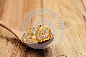 Fish Oil Capsules on Wooden Spoon