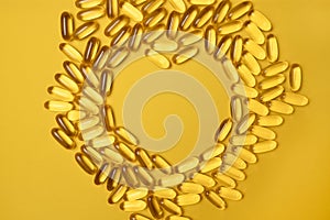 Fish oil omega 3 gel capsules isolated on yellow background. Healthcare concept