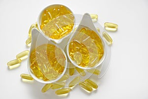 Fish oil.omega 3 gelatin capsules in white ceramic cups .omega fatty acids.Natural supplements and vitamin