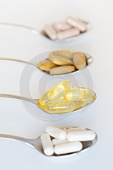 Fish oil and other healthy supplements on a teaspoon