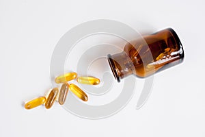 Fish oil pills glass bottle on white background top view