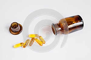 Fish oil pills glass bottle on white background top view