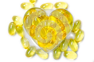 Fish oil pills on heart shape box on white background isolated