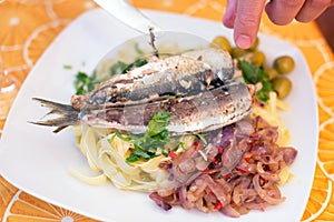 Fish and pasta on white plate