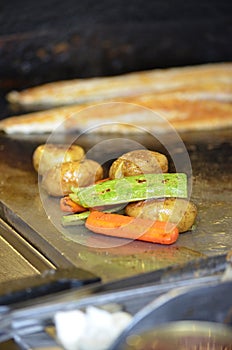 Fish, potatoes and vegetables cooking on the grill from the legendary fisherman in Bodrum