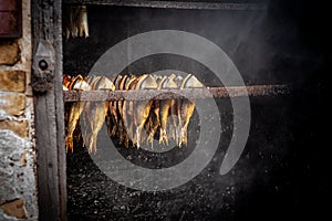 Fish processing plant. Fish of cold hot smoked. Smoked Fish In Smokehouse Box. Close Up Smoking Process Fish For Home Use.