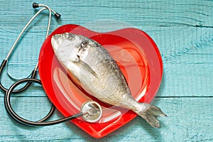 Fish on red heart plate and stethoscope