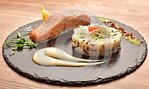 Fish and rice on a black round wooden tray