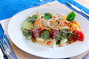 Fish salad with marinated tuna, smoked salmon, vegetables and red caviar