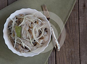 Fish salad Xe from freshly salted river fish pike on an ancient wooden table