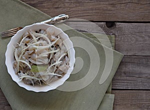 Fish salad Xe from freshly salted river fish pike on an ancient wooden table