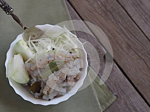 Fish salad Xe from freshly salted river fish pike on an ancient wooden table