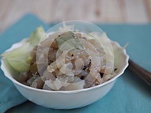 Fish salad Xe from freshly salted river fish pike on an ancient wooden table