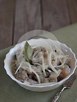 Fish salad Xe from freshly salted river fish pike on an ancient wooden table