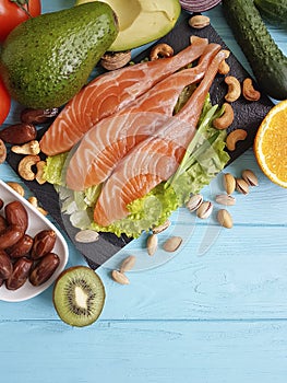 Fish salmon salad omega 3 avocado on blue wooden background healthy food