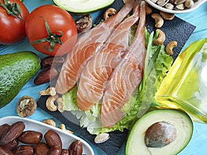 Fish salmon salad nourishment omega 3 avocado on blue wooden background healthy food