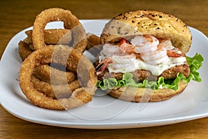 fish sandwich top with tarter sauce and shrimp