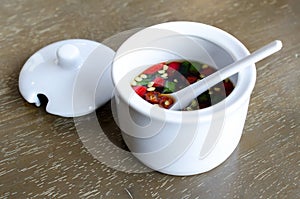 Fish Sauce Thailand in a white cup .